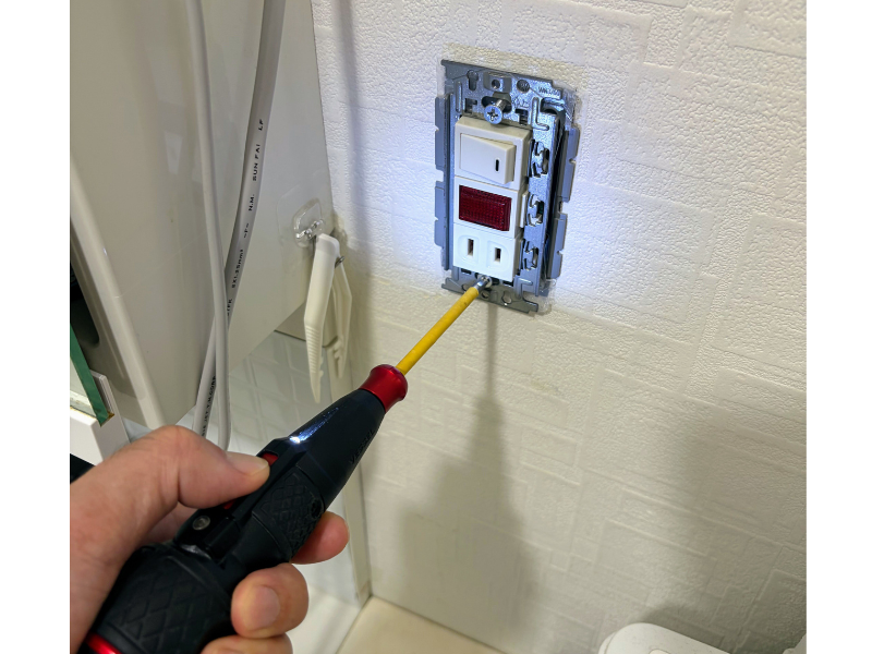 電動ドライバーでコンセントをボックスにねじ止めする様子
